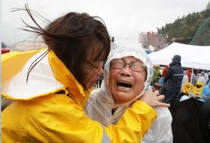 A relative weeps as she waits for missing passengers of a sunken ferry at Jindo port