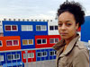 Photo: Student Rose Mandungu stands in front of a colorful apartment complex made from shipping containers in Amsterdam, The Netherlands.