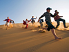 Picture of a family running down a sand dune in the Namib Desert