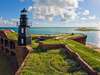 Photo: Lighthouse on grassy fort overlooking ocean