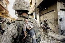 A U.S. Marine of the 1st Division carries a mascot for good luck in his backpack as his unit pushed further into the western part of Fallujah on 14 November 2004