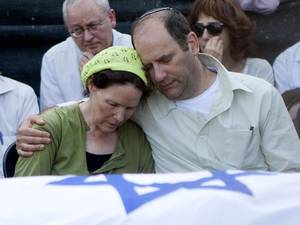 Avi and Rachel Fraenkel embrace during the funeral of their son, Naftali, a 16-year-old with dual Israeli-American citizenship, in the West Bank Jewish settlement of Nof Ayalon