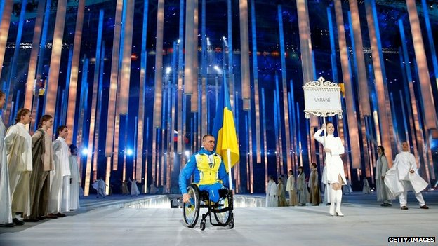 Mykhaylo Tkachenko carries the Ukraine flag at the opening ceremony of the Paralympics in Sochi