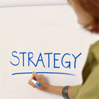 image of a woman writing strategy on a white board