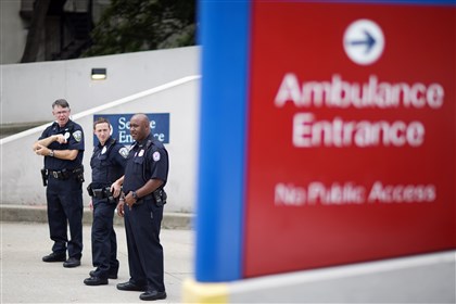  Police officers guard an entrance to Emory University Hospital after an ambulance arrived transporting an American that was infected with the Ebola virus, in Atlanta. 