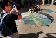  Carnegie Mellon student Kevin Louie takes a picture of fellow students Dan Kelley, Dale Zhang and Mahir Kothari interacting with a 3D chalk drawing on the sidewalk outside of the Carnegie Mellon University Center.