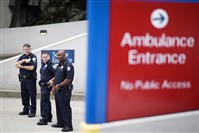 Police officers guard an entrance to Emory University Hospital after an ambulance arrived transporting an American that was infected with the Ebola virus, in Atlanta.  
