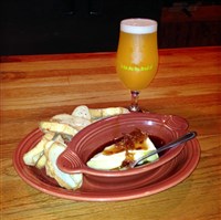  The 'Bees Knees' appetizer of warm brie topped with a bacon and shallot jam, served with toasted baguette and paired with a pint of the 'Horse Shu' Gose-style beer at ShuBrew Handcrafted Ales and Food in Zelienople. 