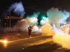A demonstrator, protesting the shooting death of teenager Michael Brown, stands his ground as police fire tear gas in Ferguson