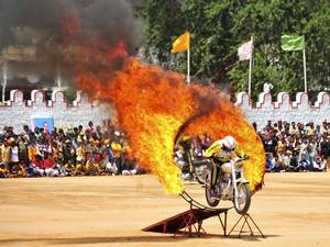 15 August 2014: An Indian army soldier performs a stunt on his motorcycle during India's Independence Day celebrations in the southern Indian city of Bangalore