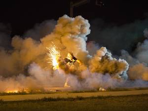 A protester throws back a smoke bomb while clashing with police in Ferguson