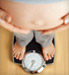 Pregnant woman looking down at belly