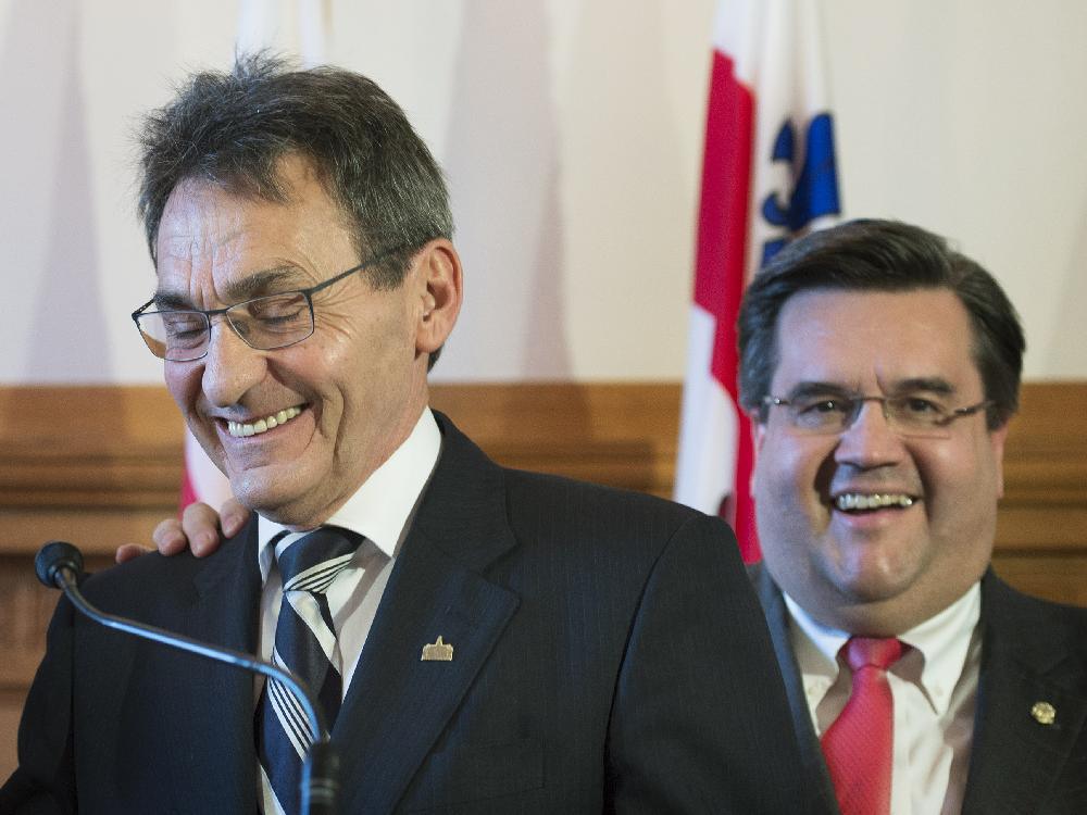 Montreal Mayor Denis Coderre, right, pats Richard Bergeron on the back during a news conference at City Hall in Montreal, Tuesday, November 18, 2014, where it was announced that Bergeron would be joining the Executive Committee.