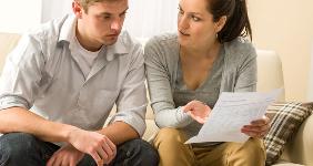 Worried young couple sitting reviewing documents © baranq/Shutterstock.com