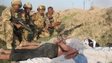 British soldiers with Iraqi detainees, who are bound and lying face-down on the ground