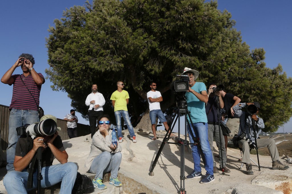 Israelis and journalists stand on a hill overlooking the Gaza Strip observing military activites on the sixth day of Operation Protective Edge, July 13, 2014. Photo: Miriam Alster / Flash90