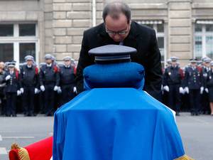 13 January 2015: French President Francois Hollande holds a medal in front of the coffin of late police officer Frank Brinsolaro during a national tribute at the Paris Prefecture for the three police officers killed during the attacks by Islamic militants