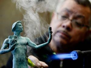 13 January 2015: Joaquin Quintero applies a green-black patina to one of the bronze Screen Actors Guild Award statuettes at the American Fine Arts Foundry in preparation of the 21st Annual SAG Awards Casting Of The Actor in Burbank, California