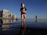 Brodie Harsh, center, walks on the beach as his aunt Dusty Sherriffs, right, passes behind Wednesday, March 4, 2015, in Coronado, Calif. (AP Photo/Gregory Bull)