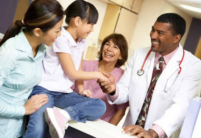 Photo of patient care with a young girl patient meeting a doctor and a nurse with her mother