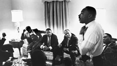 Reverend Dr. Martin Luther King, Jr. speaking with a group of Freedom Riders, including (center) Ralph Abernathy and James Farmer.