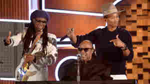 Nile Rodgers (left) and Pharrell Williams (right) on stage with Stevie Wonder during a performance of Daft Punk's "Get Lucky" during the 2014 Grammy Awards.