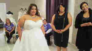 Bride Jennifer Uniglicht tries on a gown at Curvaceous Couture, a bridal boutique specializing in plus-size designer gowns. Proprietors Yukia Walker and Yuneisia Harris (right) star in the new TLC show, Curvy Brides.