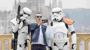 In Budapest, Hungary, a man takes a photo with people dressed as their favorite Star Wars stormtroopers.