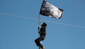 Member of Nusra Front hoists flag above Idlib-area city retaken from ISIS. May 29, 2015.