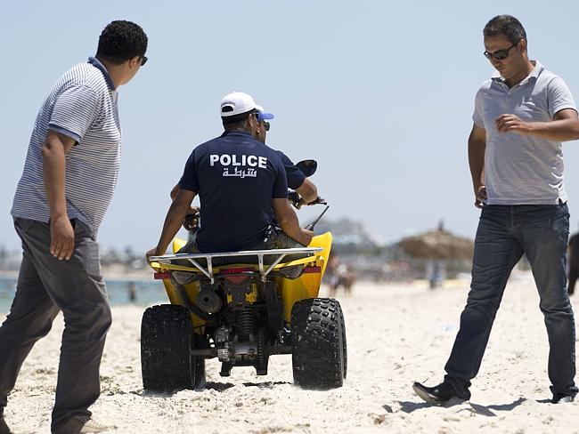 Searching ... Tunisian police patrol the beach in front of the Riu Imperial Marhaba Hotel