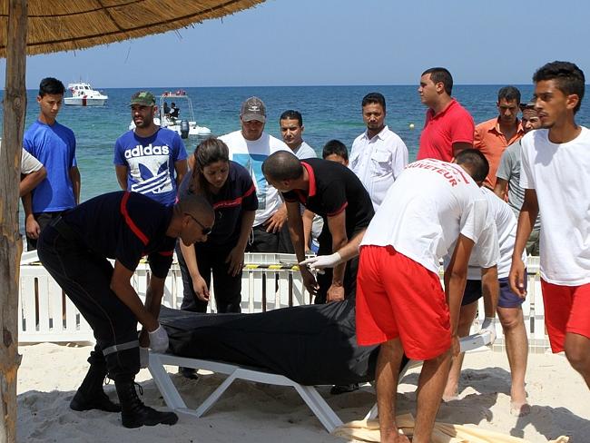 Holiday nightmare .... Tunisian lifeguards and medics transport a covered body in the res