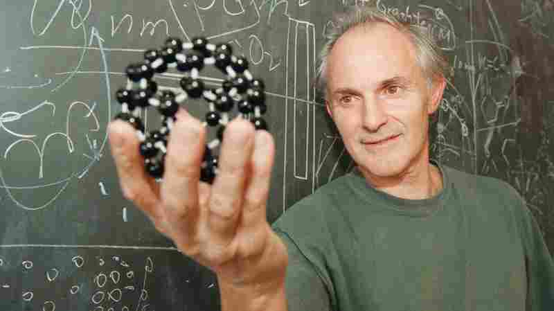 Harry Kroto, pictured in 1996, displays a model of the geodesic-shaped carbon molecules that he helped discover.