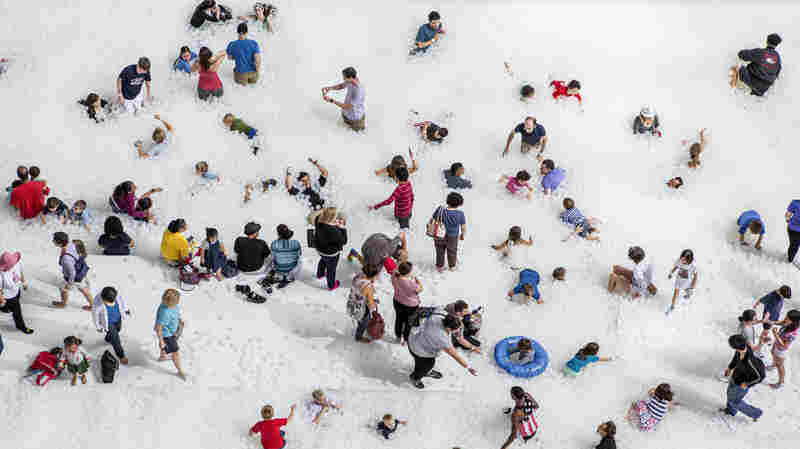 Museumgoers play in the 10,000-square-foot exhibition called "The Beach" at the National Building Museum in Washington, D.C.