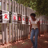 A woman walks past a banner placed around the perimeter of the Rand Afrikaans University in Johannesburg on World AIDS Day. The university used the banner to raise public awareness about AIDS and the devastating toll the disease has had in South Africa. 