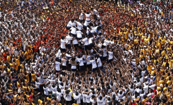 (Devotees try to form a human pyramid to break a clay pot containing curd during the celebrations to mark the Hindu festival of Janmashtami in Mumbai August 18, 2014. Janmashtami, which marks the birthday of Hindu god Krishna, is being celebrated across the country today. REUTERS/Shailesh Andrade)