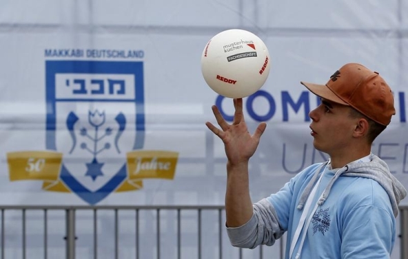 (Several weeks before the brawl, Berlin hosted the Maccabi Games, the so-called "Jewish Olymppics", for the first time. A volunteer plays with a ball outside the Olympic Park during preparations for the 14th European Maccabi Games in Berlin, Germany July 27, 2015. Jewish athletes from dozens of nations will compete during the event, held in Germany for the first time in its history, according to the organisers. REUTERS/Fabrizio Bensch)