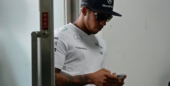 Lewis Hamilton uses a mobile phone