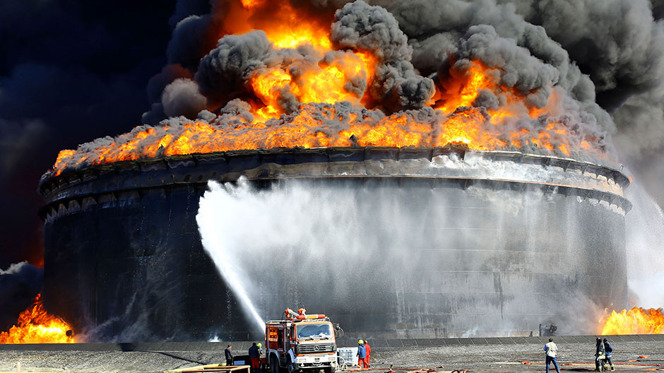 Firefighters work to put out the fire of a storage oil tank at the port of Es Sider in Ras Lanuf December 29, 2014.