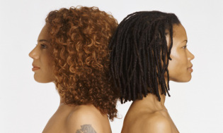 Studio Portrait of Two Young Women Back to Back, One With a Tattoo
