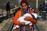 Stranded migrant holds baby, waits next to Greek-Macedonian border