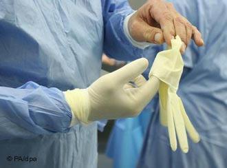 Surgeon slips on gloves