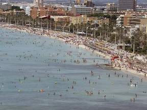 Tourists crowd Palma de Mallorca's Arenal beach