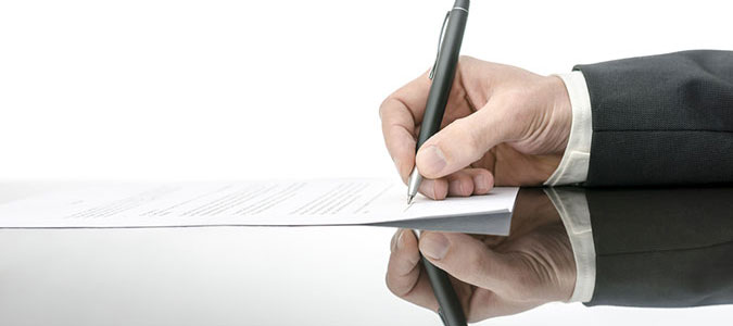 person signing document with a pen