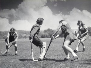 Students playing field hockey in the 1950s.