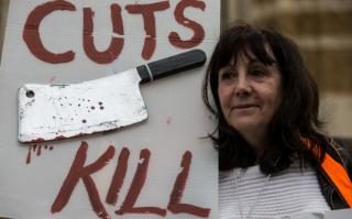 A woman holds a placard as junior doctors and supporters take part in a demonstration outside the Department of Health on April 6, 2016 in London, Englan