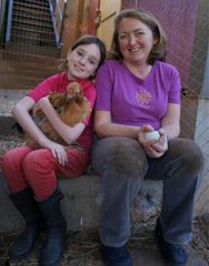 	Mother and Daughter sit and hold a chicken