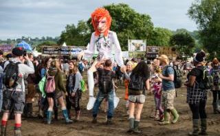 Live: A festival goer carries an oversized puppet of British singer David Bowie at the Glastonbury festival