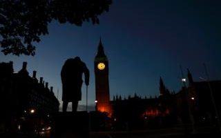 Comment: Dawn breaks behind the Houses of Parliament and the statue of Winston Churchill in Westminster, London