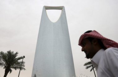Man walks past the Kingdom Centre Tower in Riyadh