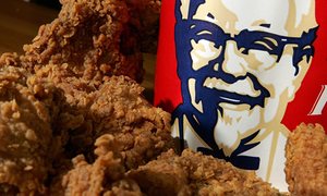 Fried chicken nuggets in front of a KFC logo
